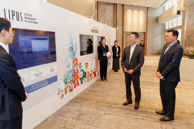 롯데는 12일 롯데월드타워에서 '2025 롯데 디자인전략회의'를 개최했다. 신동빈 롯데 회장(오른쪽)과 이돈태 롯데지주 디자인실장(오른쪽 두번째)이 롯데의 디자인 전략·혁신 사례를 소개하는 전시 부스를 살펴보고 있다. 롯데 제공