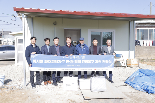 지난 12일 전북 완주군 이서면 화재피해 가구 긴급구호작업에 나선 한국전기안전공사 등 기관 관계자들이 기념촬영을 하고 있다. 전기안전공사 제공