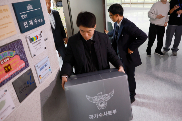 통일교 금품 수수 의혹과 관련해 15일 국회의원회관 전재수 의원실 압수수색에 나선 경찰 관계자들이 압수물을 박스에 담아 옮기고 있다. 연합뉴스