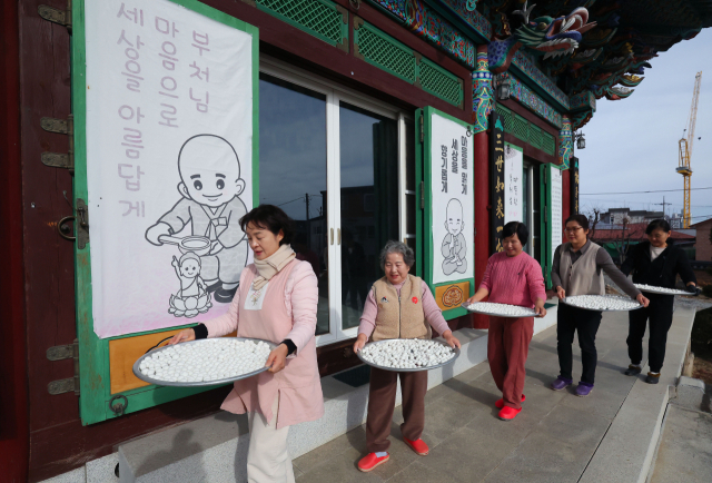 동지(冬至)를 하루 앞둔 21일 경남 함양군 함양읍 보림사에서 신도들이 동지 팥죽에 들어갈 새알을 정성스레 빚고 있다. 동지 팥죽에는 찹쌀을 동그랗게 빚은 새알을 나이 수만큼 넣어 먹는데 이 때문에 동지를 지나야 한 살 더 먹는다는 말이 있다. 함양군 제공