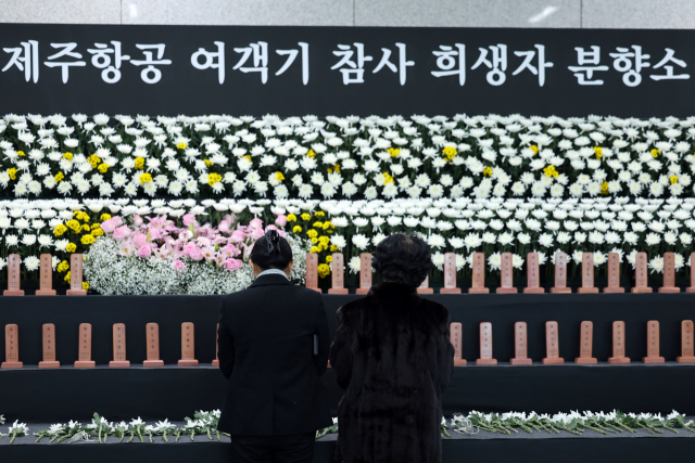 12·29 제주항공 여객기 참사 1주기를 하루 앞둔 28일 전남 무안국제공항 1층 합동분향소에서 추모객들이 헌화하고 있다. 연합뉴스