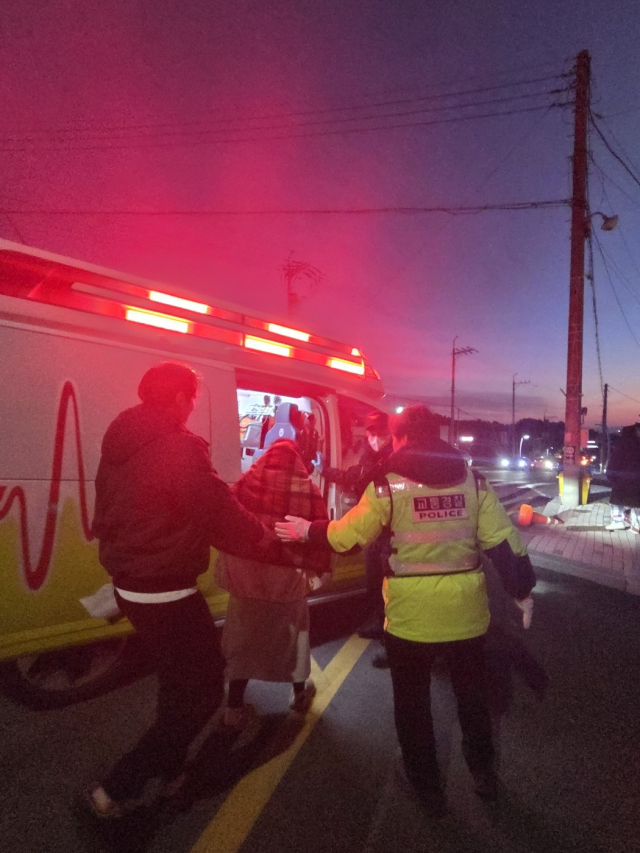 1일 오전 울산 울주군 서생면 대송마을회관 인근 해맞이 행사장에서 경찰이 통증을 호소하는 임산부를 119 구급차로 인계하고 있다. 울산경찰청 제공