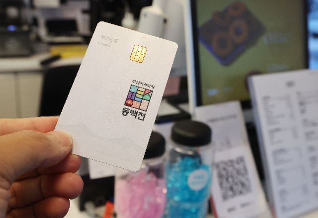 부산 중구청이 동백전 적립금을 추가로 지급하는 사업을 추진한다. 사진은 지난해 7월 한 시민이 동백전 카드로 결제를 하는 모습. 부산일보DB