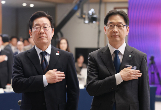 이재명 대통령이 지난해 12월 8일 용산 대통령실 청사에서 열린 지방시대위원회 보고회에서 국기에 경례하고 있다. 오른쪽은 김경수 지방시대위원장. 연합뉴스