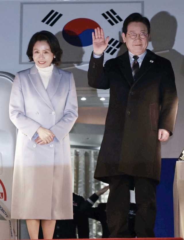 중국 방문 공식일정을 마친 이재명 대통령과 김혜경 여사가 7일 상하이 푸둥 공항 한국행 공군 1호기에서 환송객에게 인사하고 있다. 연합뉴스
