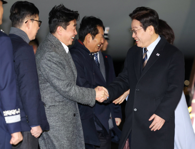 중국 국빈방문 일정을 마치고 귀국한 이재명 대통령이 7일 성남 서울공항에서 환영나온 강훈식 대통령비서실장과 인사하고 있다. 연합뉴스