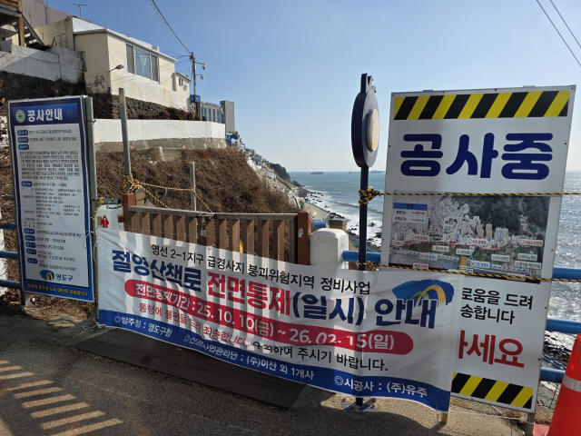 부산 영도의 해안 절경을 바라보며 산책할 수 있는 흰여울문화마을 해안산책로 경사지 공사 완공이 두 차례 연기됐다. 사진은 진입 불가 현수막이 설치된 해안산책로 진입 계단 모습. 김재량 기자 ryang@