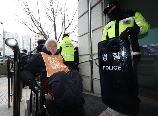 박경석 전국장애인차별철폐연대 대표가 12일 서울 종로구 혜화경찰서 앞에서 서울경찰청 표적수사 규탄 및 합동 출석 입장 발표 기자회견을 마친 뒤 청사로 들어서고 있다. 연합뉴스