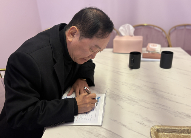 최구식 전 한나라당 국회의원이 더불어민주당 입당원서를 작성하고 있다. 본인 제공