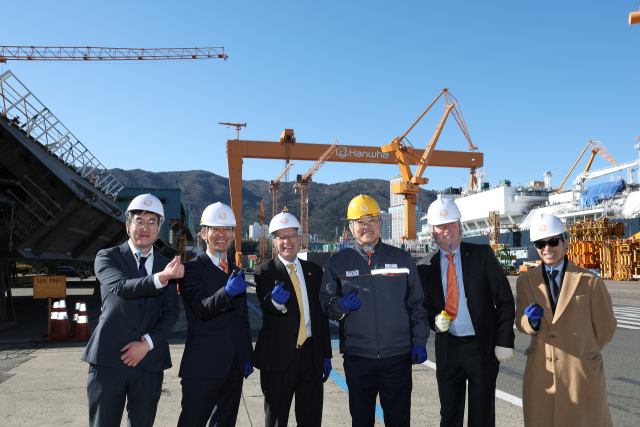 22일 빅터 피델리(Victor Fedeli) 캐나다 온타리오주 경제개발부 장관(왼쪽에서 세번째)이 김희철 한화오션 대표이사(왼쪽에서 네번째) 등과 함께 대형 골리앗 크레인을 배경으로 기념사진을 찍고 있다. 한화오션 제공
