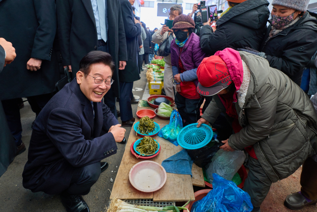 이재명 대통령이 23일 울산 울주군 온양읍 남창옹기종기시장을 방문해 나물을 구매하고 있다. 연합뉴스