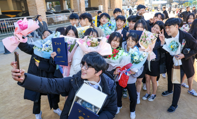 지난해 1월 13일 부산 수영구 한바다중학교에서 열린 제53회 졸업식에서 졸업생들이 기념사진을 찍으며 추억을 남기고 있다. 부산일보DB