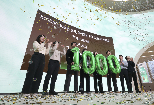 코스닥 지수가 4년여만에 1,000선을 넘어선 26일 서울 중구 하나은행 본점 딜링룸에서 딜러들이 세리머니를 하고 있다. 연합뉴스