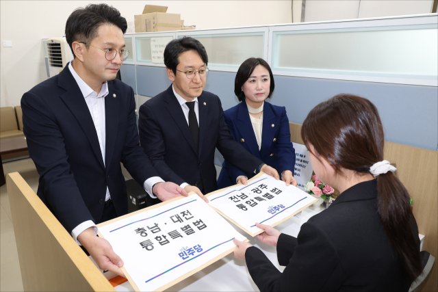 더불어민주당 천준호 원내운영수석부대표(가운데), 전용기 원내소통수석부대표(왼쪽), 백승아 원내대변인이 30일 국회 의안과에 충남대전통합특별법안과 전남광주통합특별법안을 제출하고 있다. 연합뉴스
