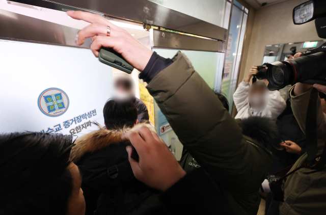 통일교·신천지의 정교 유착 의혹을 수사하는 검·경 합동수사본부가 '당원 가입 의혹'을 받는 신천지에 대한 강제수사에 착수했다. 30일 경기도 과천시 신천지 총회 본부에서 한 관계자가 내부로 들어서고 있다. 연합뉴스