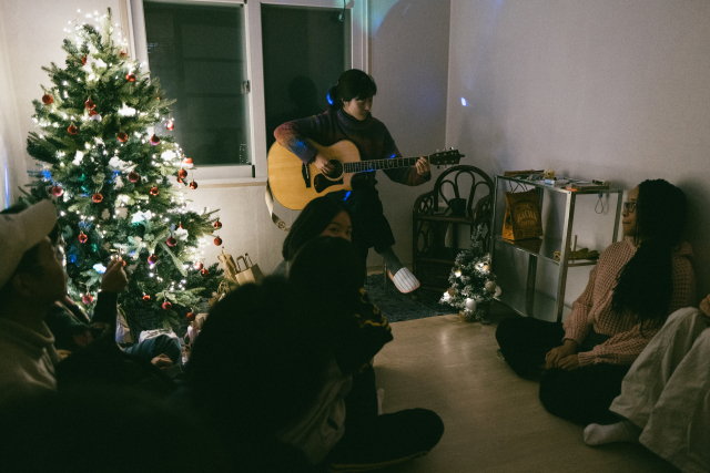 지난해 12월 26일 경남 남해군의 한 게스트하우스에서 안지원 씨가 주민들 앞에서 작은 공연을 열고 있다. 본인 제공