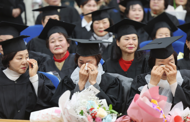 졸업식에서 만학도들이 졸업생들이 눈물을 훔치고 있다.