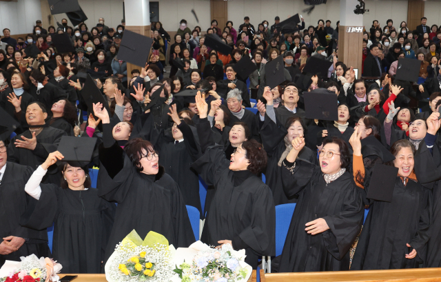 졸업식이 끝난 졸업생들이 모자를 높이 던지고 있다.