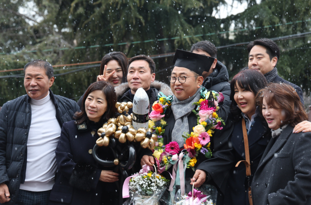이날 눈이 내리는 가운데 졸업생이 기념촬영을 하고 있다.