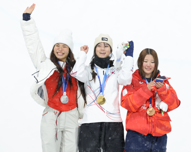 12일(현지시간) 이탈리아 리비뇨 스노파크에서 열린 2026 밀라노·코르티나담페초 동계 올림픽 스키 스노보드 여자 하프파이프 결선에서 90.25점을 획득해 금메달을 획득한 한국 최가온이 은메달을 획득한 미국의 클로이 김, 동메달을 획득한 일본의 오노 미쓰키와 기뻐하고 있다. 연합뉴스