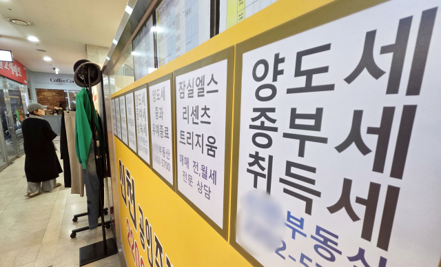 '다주택자 양도소득세 중과' 조치가 오는 5월 9일부터 재시행된다. 다주택자가 보유한 조정대상지역 주택 양도차익에는 최고 75%(지방세 포함 82.5%)의 세율이 적용된다. 12일 서울 시내 한 공인중개사 사무실 외벽에 부동산 관련 세금과 아파트 매매 물건 등의 안내문이 게시되어 있다. 연합뉴스