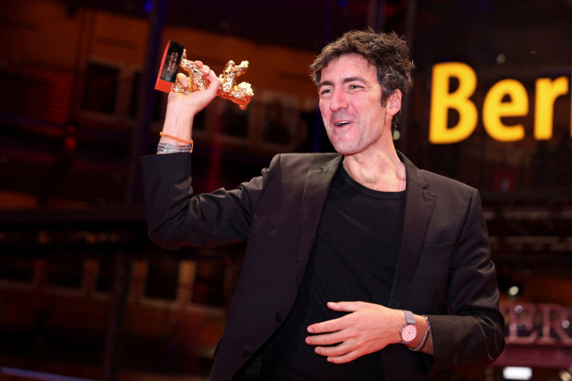 21일(현지시간) 열린 제76회 베를린국제영화제 폐막식에서 '옐로 레터스'로 황금곰상을 받은 일케르 차탁 감독이 트로피를 들고 포즈를 취하고 있다. 로이터연합뉴스