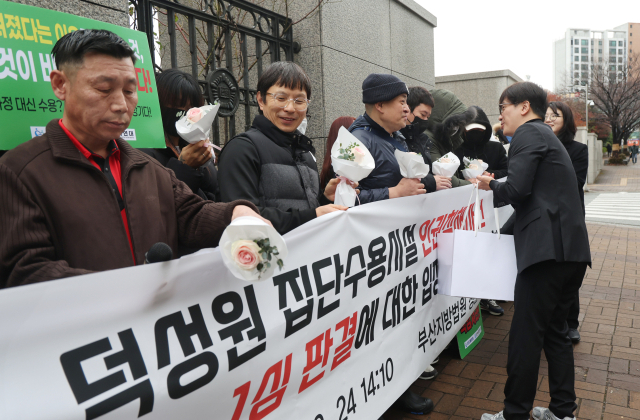 지난해 12월 부산 연제구 부산지방법원 앞에서 덕성원 피해자들이 손해배상 청구 판결에 대한 기자회견 중 꽃다발을 받고 있다. 이재찬 기자 chan@