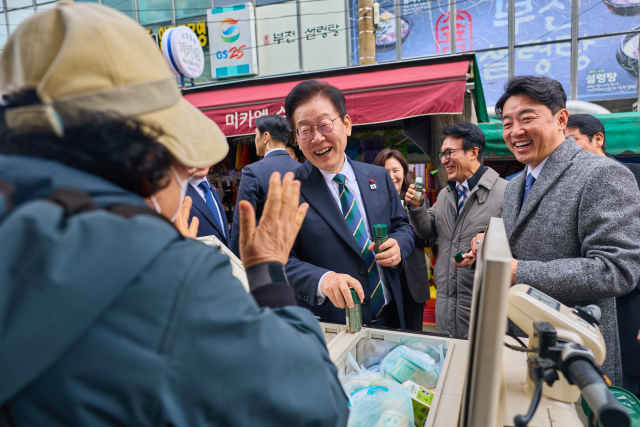 이재명 대통령이 지난해 12월 23일 해양수산부 청사에서 국무회의를 마친 뒤 부산 부산진구 부전시장을 찾아 상인들과 이야기를 나누고 있다. 연합뉴스