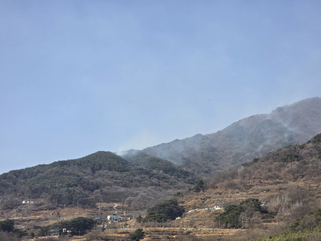 23일 오후 1시 함양군 마천면 산불 현장 모습. 진화율이 80%를 넘어선 가운데 능선에서 연기가 피어오르고 있다. 김현우 기자
