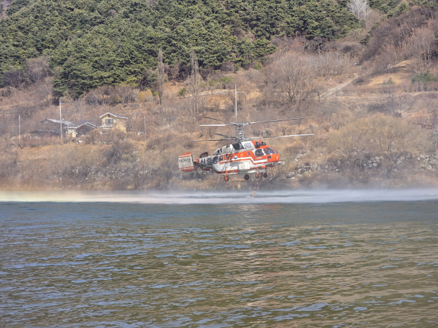 23일 산불 현장 인근 하천에서 산림청 산불 진화 헬기가 물을 채우고 있다. 김현우 기자