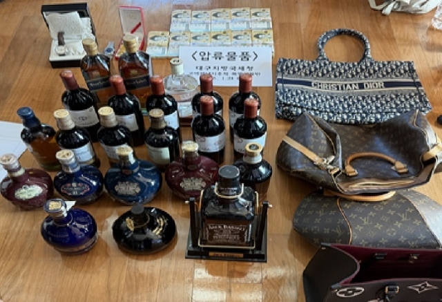 체납자의 거주지에서 발견된 명품 핸드백과 양주, 고가시계 현금 등. 국세청 제공