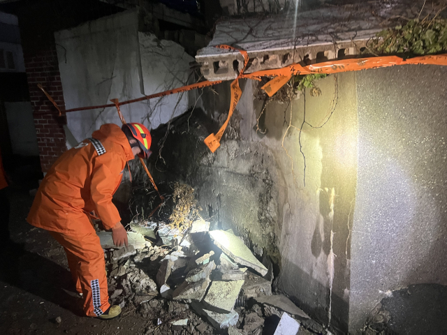 부산 전역에 강풍주의보가 발효된 2일 사하구 괴정동에서 옹벽이 무너져 통행에 지장을 준다는 신고가 접수돼 소방 당국이 안전조치를 진행하는 모습. 부산소방재난본부 제공.