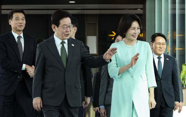 싱가포르 국빈방문을 마친 이재명 대통령과 김혜경 여사가 3일 창이 국제공항에서 다음 순방지인 필리핀 마닐라로 향하는 공군 1호기로 이동하며 공항직원들에게 인사하고 있다. 연합뉴스