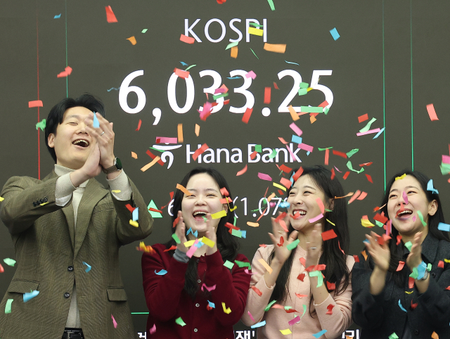 코스피가 장중 6000포인트를 넘어선 지난달 25일, 서울 중구 하나은행 본점 딜링룸 직원들이 기뻐하고 있다. 연합뉴스