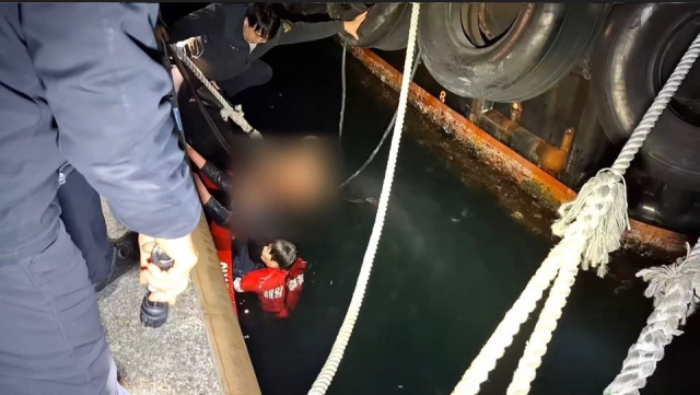 7일 오후 경남 창원시 마산합포구 마산항 인근 바다에 빠진 50대 남성들을 해양경찰관이 구조하고 있다. 창원해양경찰서 제공