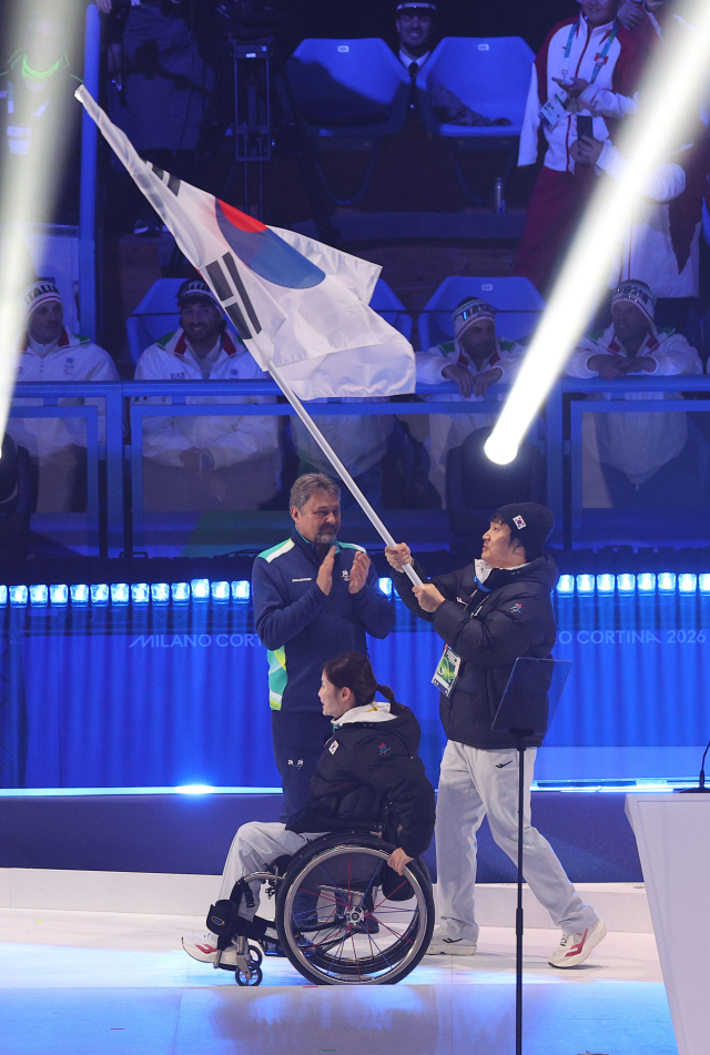 한국 선수단의 이제혁과 백혜진이 15일(현지 시간) 이탈리아 코르티나 컬링 올림픽 스타디움에서 열린 2026 밀라노·코르티나담페초 동계 패럴림픽 폐막식에서 입장학 있다.연합뉴스