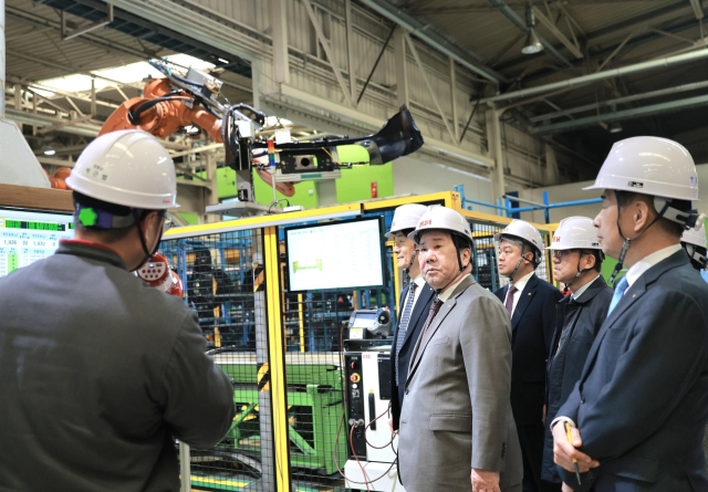 SM그룹 우오현 회장(가운데)이 지난 16일 경북 구미시 티케이케미칼의 합성수지 생산공장에서 이충근 케미칼사업부장(왼쪽)으로부터 현장 운영현황과 제품에 대해 보고를 받고 있다. SM그룹 제공