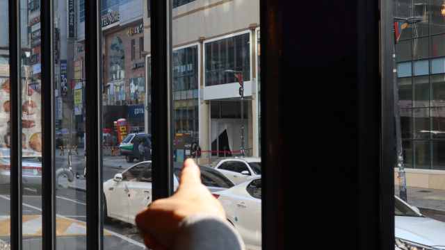 19일 경남 창원시 성산구 중앙동 한 제과점 점주가 40m 앞 호텔 건물을 가리키고 있다. 대기업 제과점이 들어설 곳으로, 점주 손가락이 가리키는 방향에 외부 출입문을 설치하려는 흔적이 보인다. 최환석 기자