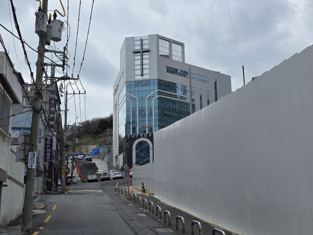 23일 부산 남구 대연중학교 후문 통학로 모습. 학생들의 안전한 통학을 위한 볼라드와 공사장 외벽이 설치됐지만, 여전히 추가 안전 장치가 필요한 상황이다. 김재량 기자 ryang@