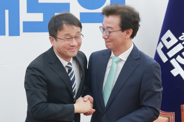 더불어민주당 한병도 원내대표가 24일 국회에서 열린 부산 글로벌허브도시 조성에 관한 특별법안 관련 간담회에 참석해 발언을 마친 뒤 민주당 전재수 의원과 악수하고 있다. 연합뉴스