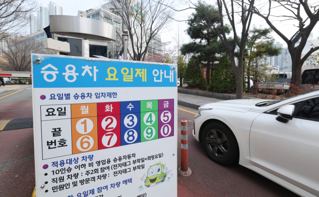 정부가 에너지 절약을 위해 공공부문 ‘승용차 5부제(요일제)’를 25일 0시를 기해 의무화했다. 사진은 24일 부산 연제구청 주차장에 설치된 승용차 요일제 안내문. 정종회 기자 jjh@