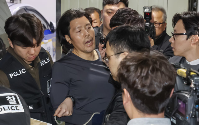 항공사 기장을 살해한 혐의로 구속된 김동환(49)이 검찰에 송치되기 위해 지난달 26일 오전 부산 부산진경찰서에서 호송차량으로 이동하고 있다. 김종진 기자 kjj1761@