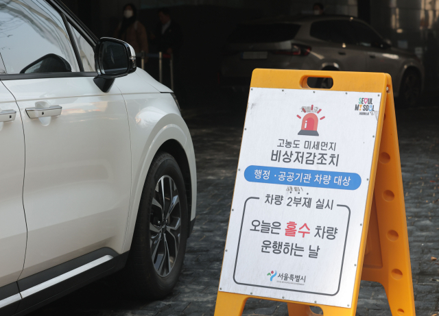 서울시가 미세먼지 비상저감조치를 시행한 지난달 17일 서울시청 주차장 입구에 행정·공공기관 차량 대상 2부제 실시 안내문이 설치돼 있다. 연합뉴스