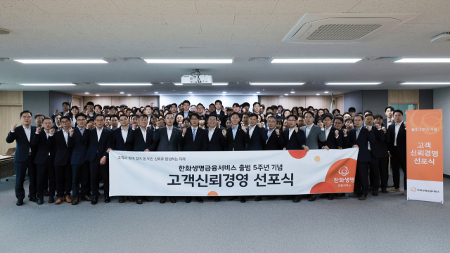 한화생명금융서비스 최승영 대표이사(앞줄 왼쪽에서 아홉 번째)를 비롯한 임직원들이 1일 서울 여의도 63빌딩에서 열린 출범 5주년 기념 ‘고객신뢰경영 선포식’에서 기념촬영을 하고 있다. 한화생명금융서비스 제공.