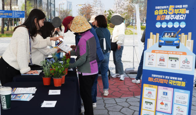 한전KPS가 3일 나주 빛가람호수공원에서 ‘에너지절약 캠페인 및 묘목 나눔 행사’를 펼치고 있는 가운데 한 시민이 에너지 절약 국민행동 요령을 안내받고 있다. 한전KPS 제공