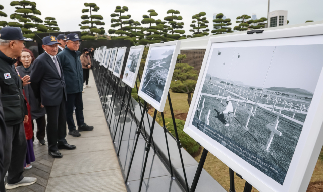6일 부산 남구 대연동 유엔기념공원 정문 광장에서 유엔기념공원 조성 75주년을 기념하는 기록사진 특별전이 열려 참석자들이 사진을 감상하고 있다. 30일까지 계속되는 이번 전시는 공원의 조성과정을 담은 기록사진 약 20점을 통해 전쟁 중 조성된 묘지의 역사를 소개한다. 김종진 기자 kjj1761@