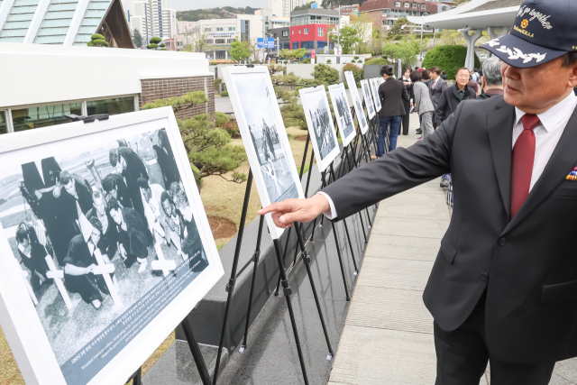 6일 부산 남구 대연동 유엔기념공원 정문 광장에서 유엔기념공원 조성 75주년을 기념하는 기록사진 특별전이 열려 참석자들이 사진을 감상하고 있다. 30일까지 계속되는 이번 전시는 공원의 조성과정을 담은 기록사진 약 20점을 통해 전쟁 중 조성된 묘지의 역사를 소개한다. 김종진 기자 kjj1761@