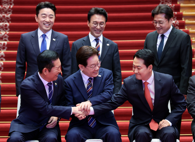 이재명 대통령이 7일 청와대에서 여야정 민생경제 협의체 회담에 앞서 기념촬영 중 더불어민주당 정청래 대표, 국민의힘 장동혁 대표와 손을 잡고 있다. 뒷줄은 왼쪽부터 강훈식 대통령비서실장, 김민석 국무총리, 홍익표 정무수석. 연합뉴스