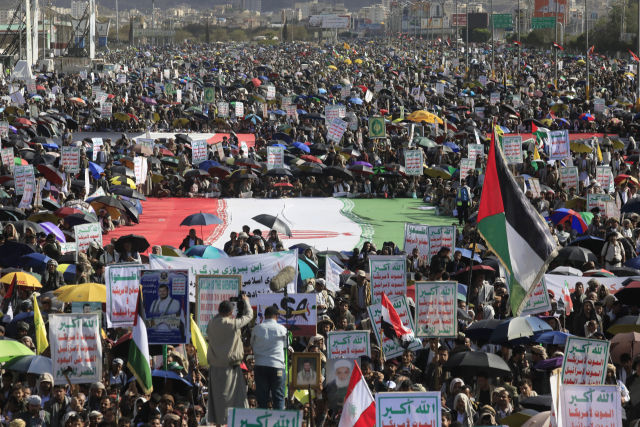 10일(현지시간) 예멘 사나에서 열린 미국·이란 휴전 협정에 따른 이란과의 연대 집회에서 후티 지지자들이 대규모 이란 국기 주변에 모여들고 있다. 연합뉴스