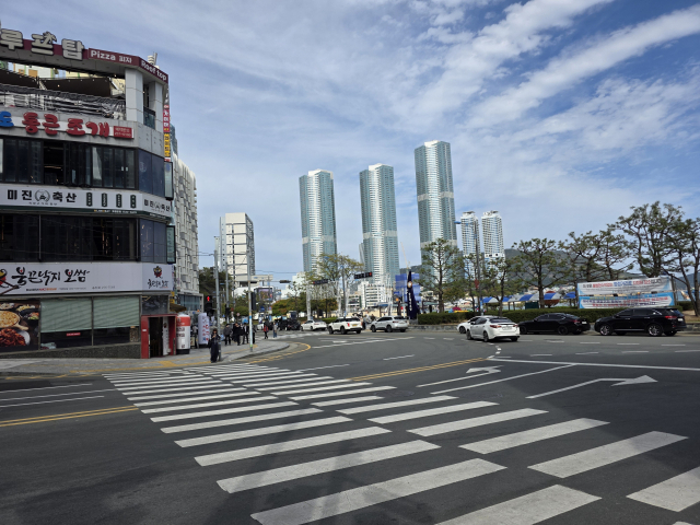 여름철마다 관광객과 차량이 쏠리는 부산 송도해수욕장 입구 앞 삼거리 교차로가 개선된다. 횡단보도 길이를 줄이고 차량 유도선을 정비해 해수욕장 혼잡과 사고 가능성을 낮추기 위해서다. 사진은 공사 예정 삼거리 횡단보도 모습. 김재량 기자 ryang@